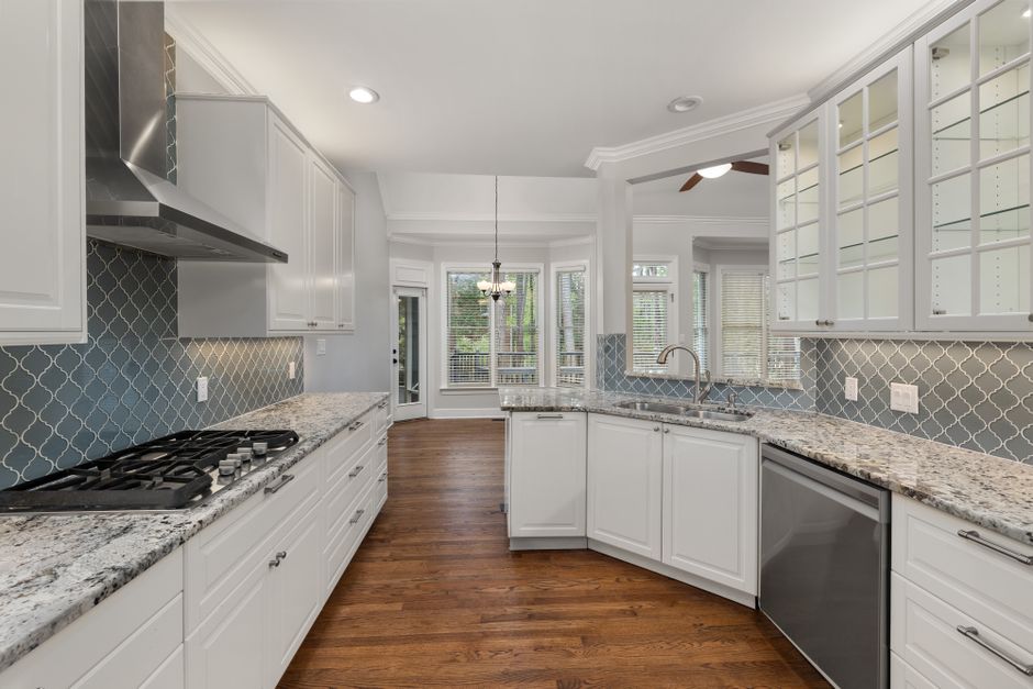 Spacious kitchen featuring granite countertops, hardwood floors, and elegant cabinets.